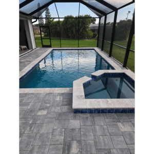 Custom shotcrete pool with attached spa and gray travertine decking built by H2Oasis Pools & Spas in Burnt Store Meadows, Florida.