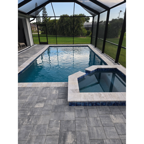 Custom shotcrete pool with attached spa and gray travertine decking built by H2Oasis Pools & Spas in Burnt Store Meadows, Florida.