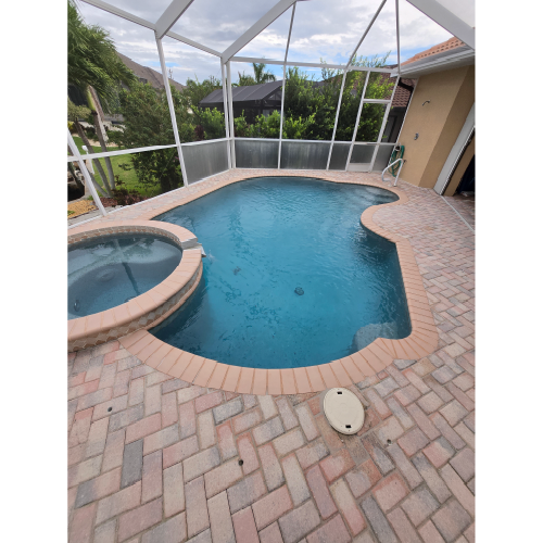 Curved residential pool with brick paver deck designed by H2Oasis Pools & Spas in Punta Gorda, Florida, ideal for custom fire and water feature installation.