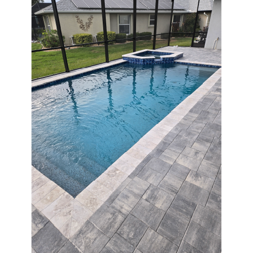 Modern rectangular pool with PebbleTec finish and light travertine decking by H2Oasis Pools & Spas in Punta Gorda, Florida.