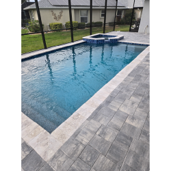 Modern rectangular pool with PebbleTec finish and light travertine decking by H2Oasis Pools & Spas in Punta Gorda, Florida.